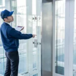 Fachkraft kontrolliert eine Aufzugsanlage in einem modernen Gebäude